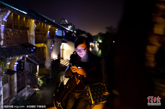 不管白天還是夜里，行走在烏鎮老街上，處處可見上網的人群。(圖片作者：梁臻)